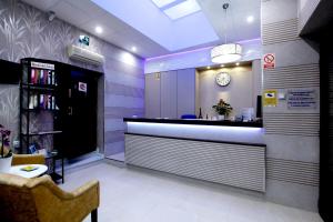 a lobby with a bar with a clock on the wall at Hostal Paris in San Fernando