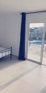 Cette chambre dispose d'une porte coulissante en verre offrant une vue sur la piscine. dans l'établissement Apartment Curacao, à Willemstad