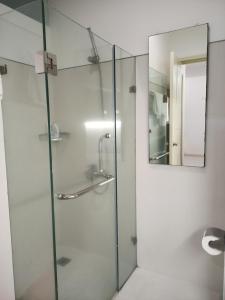 um chuveiro com uma porta de vidro e um espelho em Citihouse Ho Chi Minh Apartment em Cidade de Ho Chi Minh mais 22 fotografias