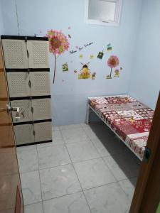 una stanza con un letto e una parete con dei fiori sopra di Eiffel Residence Cideng - Female Only a Giacarta