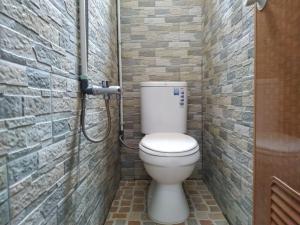 e bagno con servizi igienici in un muro di mattoni. di Eiffel Residence Cideng - Female Only a Giacarta