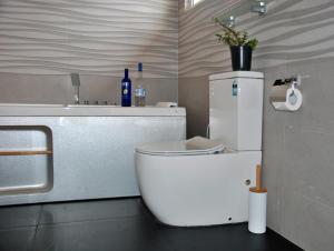 
a white toilet sitting in a bathroom next to a sink at Cottage San Francesco in Nuwara Eliya
