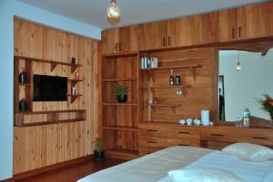 a bedroom with wooden walls and a bed and a television at Cottage San Francesco in Nuwara Eliya