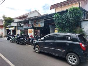 a black car parked in front of a building with motorcycles at Eiffel Residence Petojo - Female Only in Jakarta +7 photos