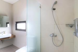 bagno con doccia e porta in vetro di M Pavilion - BSD a Serpong