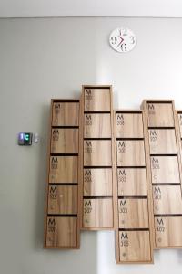 a clock on a wall with four wooden shelves at M Pavilion - BSD in Serpong