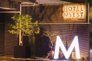 Hotel M's Est Shijo Karasuma في كيوتو: علامة الفندق على جانب مبنى به اشجار