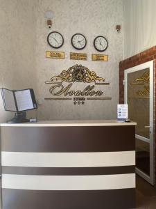a hotel reception desk with clocks on the wall at Hotel Avallon in Adler