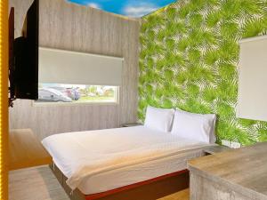 ein Schlafzimmer mit einem Bett mit einer grünen Wand in der Unterkunft 崇霖覓境-花蓮崇德瑩農場 in Chongde
