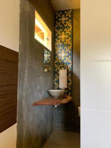 a bathroom with a sink on a wall at Casa Amarela - 3 suítes e piscina in Piranhas