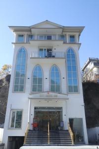 a large white building with stairs in front of it at City Choice Inn in Kulu