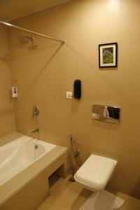 a bathroom with a toilet and a sink and a tub at The Aures (formerly known as Keys Select The Aures) in Aurangabad