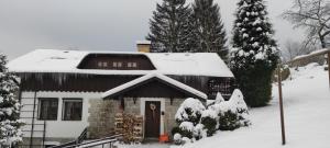 una casa con techo cubierto de nieve en Penzion U Dvou skal, en Josefŭv Dŭl