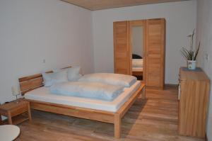 ノルトハイムにあるFerien- und Winzerhof Ute Braunのベッドルーム1室(ベッド1台、ドレッサー付)