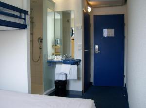 a bathroom with a blue sink and a mirror at Ibis Budget Graz City in Graz