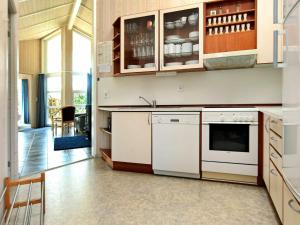 オッテルンドルフにあるFour-Bedroom Holiday home in Otterndorf 6の白いキャビネットとシンク付きのキッチン