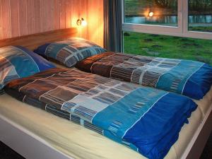 two beds sitting next to a window in a bedroom at Four-Bedroom Holiday home in Otterndorf 6 in Otterndorf