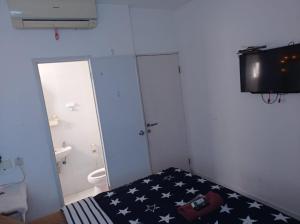 a room with a bed with an american flag bedspread at Bintang Property Aeropolis in Rawabambu