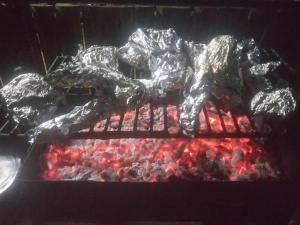 un mucchio di carne e altro cibo su una griglia di Camp Mahon Gardens a Nanyuki