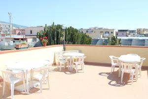 a row of white tables and chairs on a roof at Domus Felix in Ercolano