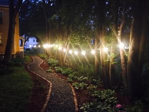 a walkway with lights in a garden at night at The Fairlawn Inn in Hunter