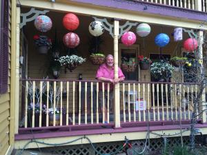 a woman standing on a porch with lanterns at The Fairlawn Inn in Hunter