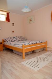 ein großes Bett in einem Zimmer mit einem Holzrahmen in der Unterkunft Mecsek Vendégház in Pécs