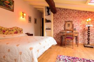 1 dormitorio con cama, mesa y escritorio en La Closerie de Fronsac, en Saint-Michel-de-Fronsac