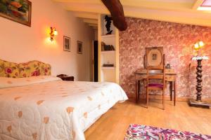 a bedroom with a bed and a table and a desk at La Closerie de Fronsac in Saint-Michel-de-Fronsac