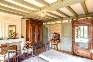 1 dormitorio con chimenea y 1 cama en una habitación en La Closerie de Fronsac, en Saint-Michel-de-Fronsac