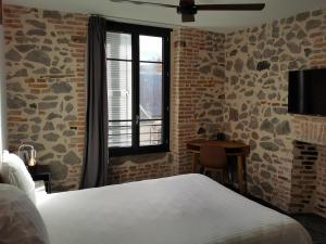 um quarto de hotel com uma cama e uma janela em Hôtel Zadig em Aurillac