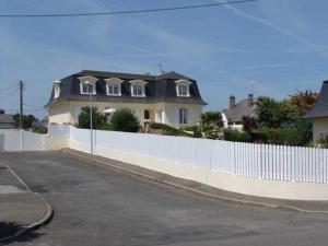 una cerca blanca frente a una casa en Chambres d'hôtes La Mansardière, en Cancale