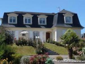 una gran casa blanca con techo negro en Chambres d'hôtes La Mansardière, en Cancale