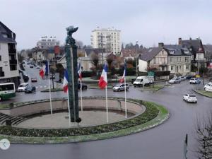 Una ciudad con una estatua en medio de una calle en Hôtel Le Hussard, en Alençon