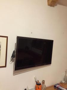 einen an der Wand hängenden Flachbild-TV in der Unterkunft Apartment in Borca di Cadore in Borca di Cadore