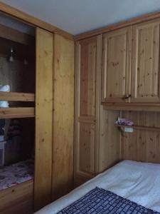 ein Schlafzimmer mit Holzschränken und einem Bett darin in der Unterkunft Apartment in Borca di Cadore in Borca di Cadore