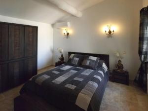 een slaapkamer met een bed en twee lampen aan de muur bij Mas Dansavan Chambres d'hôtes in Oppède