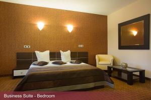 a hotel room with a bed and a chair at INTER BUSINESS Bucharest in Bucharest +61 photos