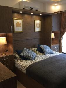 a bedroom with a large bed with blue pillows at Superior Executive Apartment in Umm Uthainah