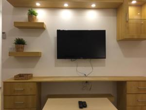 uma televisão numa parede num quarto em Superior Executive Apartment em Umm Uthainah