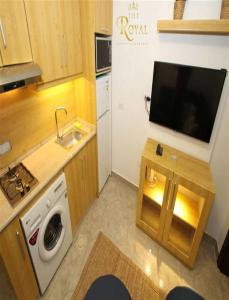 a small kitchen with a tv and a washing machine at The Royal Luxury City Budget Visit in Amman