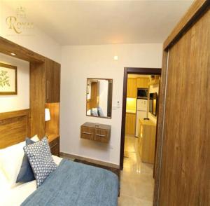 - une chambre avec un lit bleu et un miroir dans l'établissement The Royal Luxury City Budget Visit, à Amman