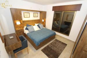 ein Schlafzimmer mit einem Bett, einem Spiegel und einem Stuhl in der Unterkunft The Royal Luxury Superior King in Amman