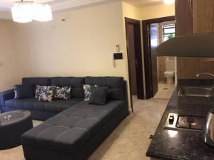 a living room with a blue couch and a kitchen at The Royal Luxury King Terrace 1 in Amman