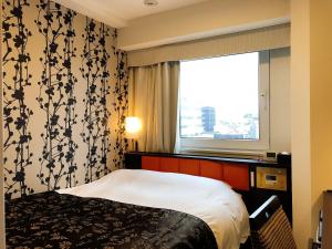 um quarto de hotel com uma cama e uma janela em APA Hotel Ueno Hirokoji em Tóquio