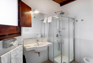 a bathroom with a sink and a glass shower at Hotel Villa Mediterranea in Noto Marina