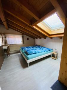 ein Schlafzimmer mit einem Bett in einem Zimmer mit einem Dachfenster in der Unterkunft Privatzimmer / bed & breakfast in Andermatt