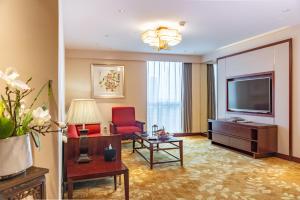 Guangzhou Baiyun International Convention Center في قوانغتشو: غرفة فندقية بتلفزيون وغرفة معيشة
