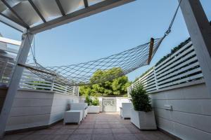 eine Terrasse mit weißen Stühlen und einem Glasdach in der Unterkunft "LUMINARIA" casa nuova in Salento fronte mare!!! in Sant'Isidoro
