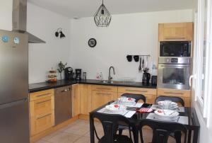 a kitchen with a table and chairs in it at Gîtes L'Escargot Bleu in Oloron-Sainte-Marie